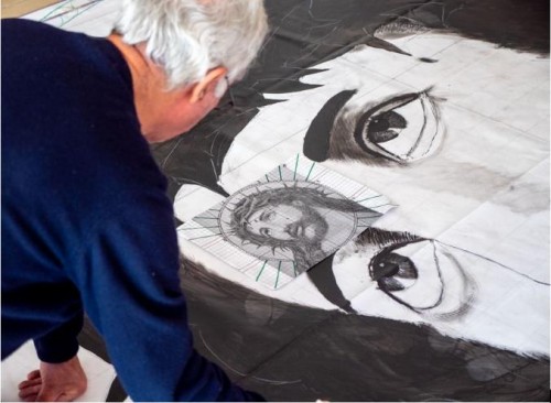 A man painting a black and white jesus.