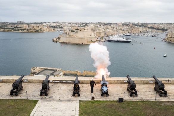 Cannons firing over a port.