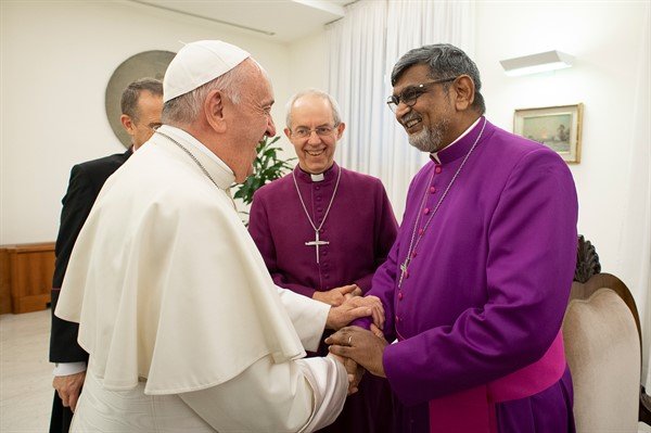 The pope shaking hands with clergy in rome.