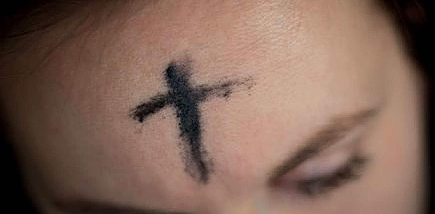 A girl with an ash cross drawn on her forehead.