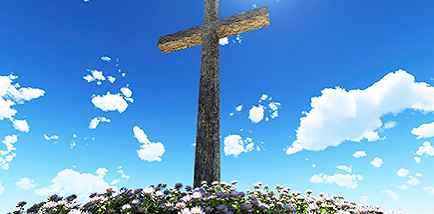 A large cross infront of a blue sky.