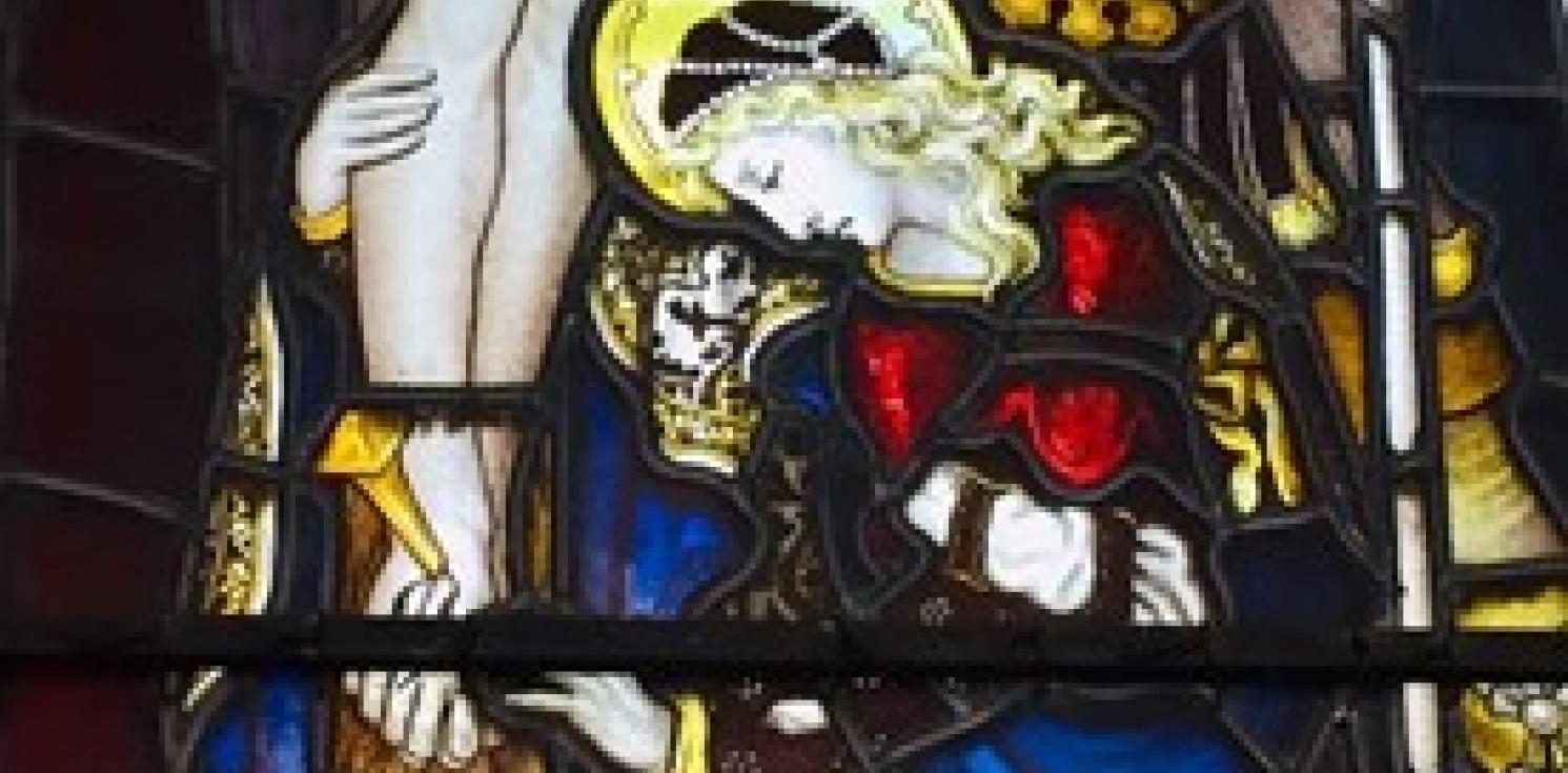 A strained glass window of Mary clinging to Jesus.