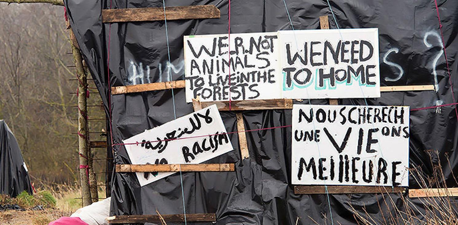Signs made by migrants asking to be treated like humans.