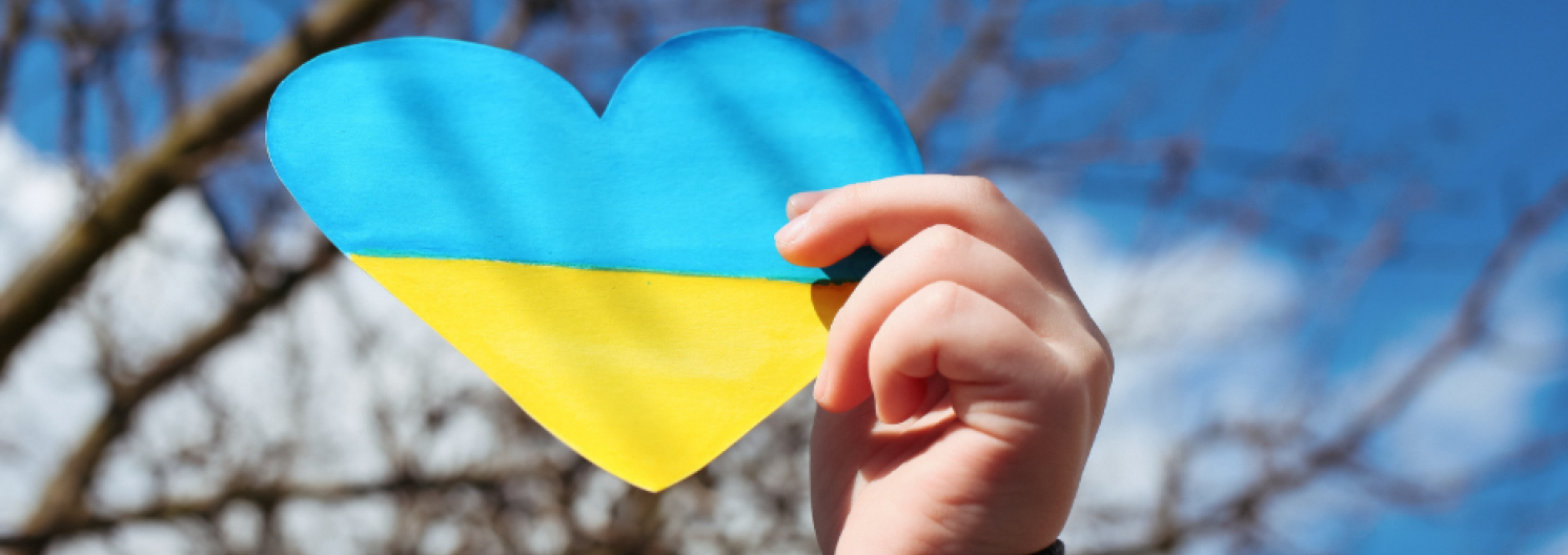 holding a Ukraine flag in a heart shape