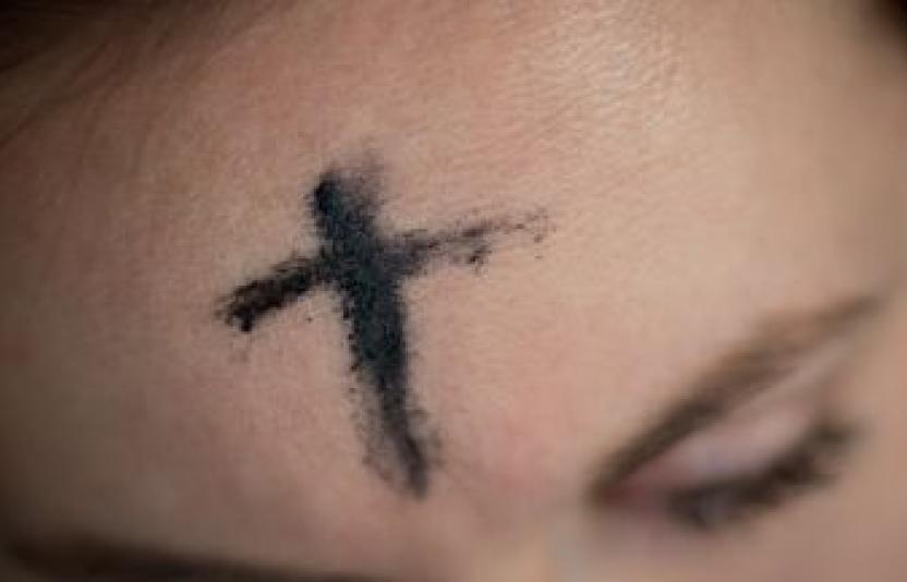 A girl with an ash cross drawn on her forehead.