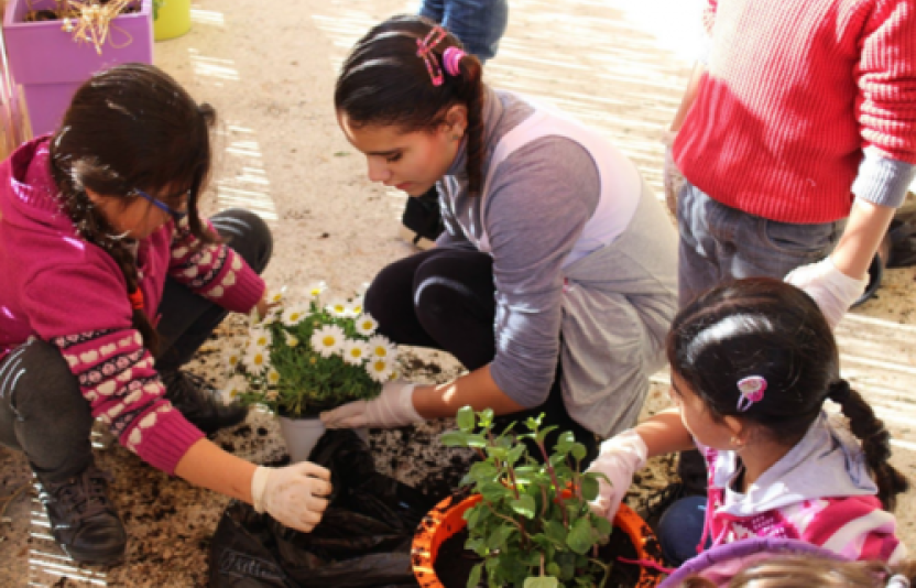 Children planting flowers in pots.