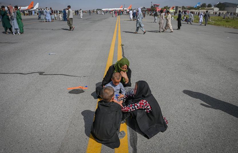 A family huddles together on Kabul Airstrip.