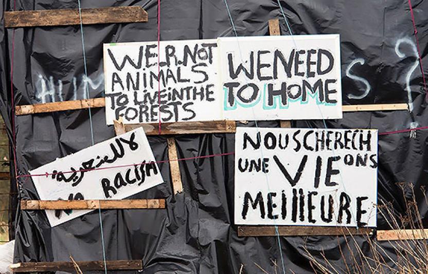 Signs made by migrants asking to be treated like humans.