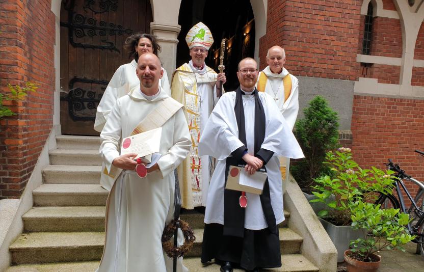 new ordinands standing on steps with bishop
