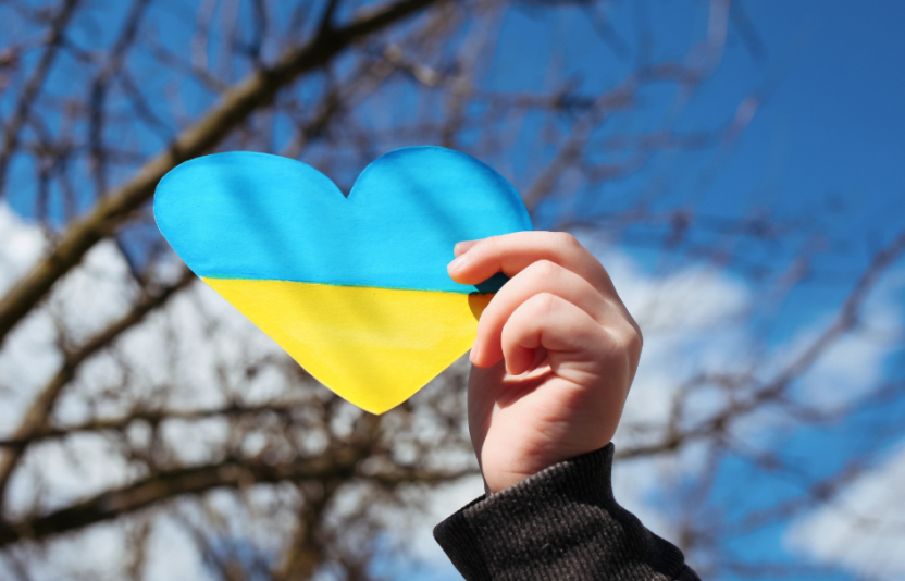 holding a Ukraine flag in a heart shape