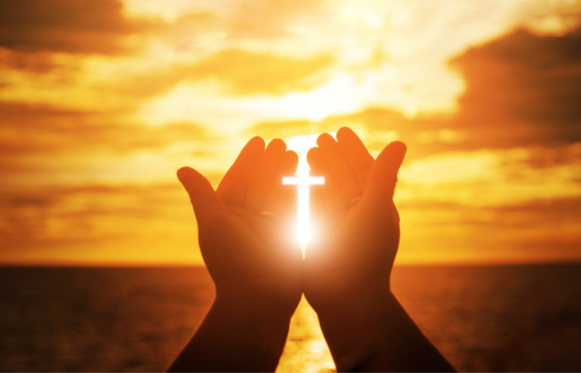 Praying hands in sunset
