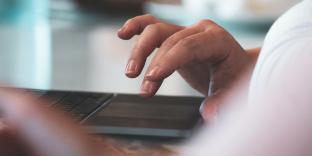 woman touching track pad on laptop