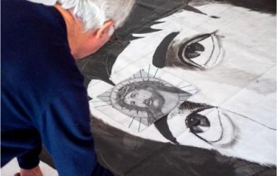 A man painting a black and white jesus.