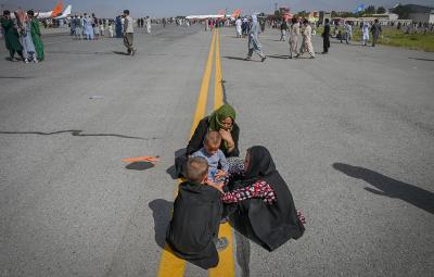 A family huddles together on Kabul Airstrip.