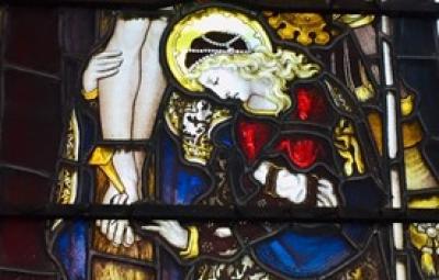 A strained glass window of Mary clinging to Jesus.