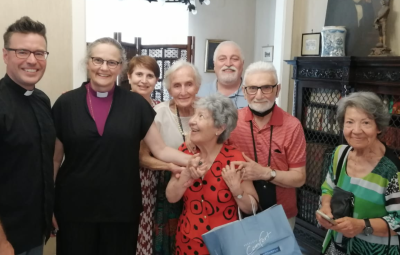 A group of smiling members of the Holy Cross church.