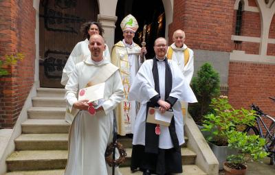 new ordinands standing on steps with bishop